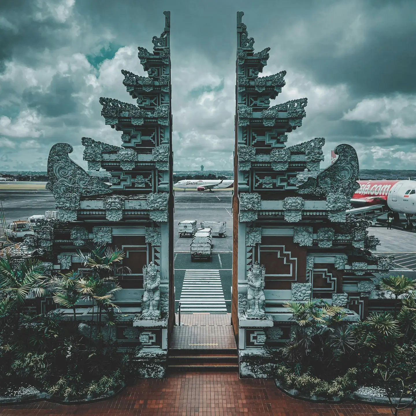 Ngurah Rai Airport Bali — traditional Balinese gate with planes on the tarmac